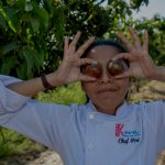 Chef Ari holding Tomatoes over her eyes