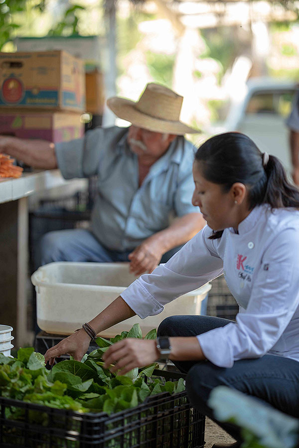 Chef Ari buying organic vegetables from her farmer.